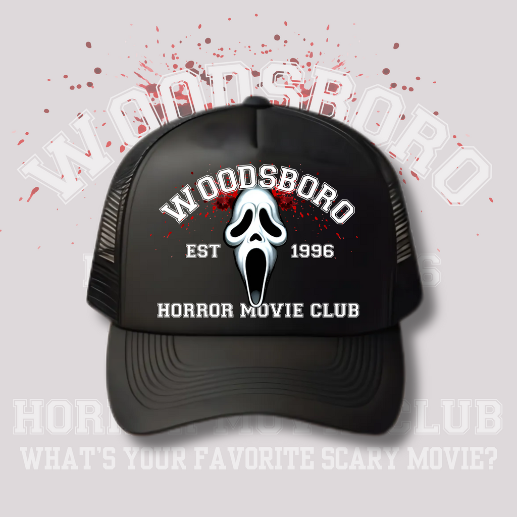 Black trucker hat featuring the Ghostface mask with white and red splatter design. Text reads “Woodsboro Est. 1996 – Horror Movie Club.” Background includes a faded Woodsboro graphic with blood splatters.