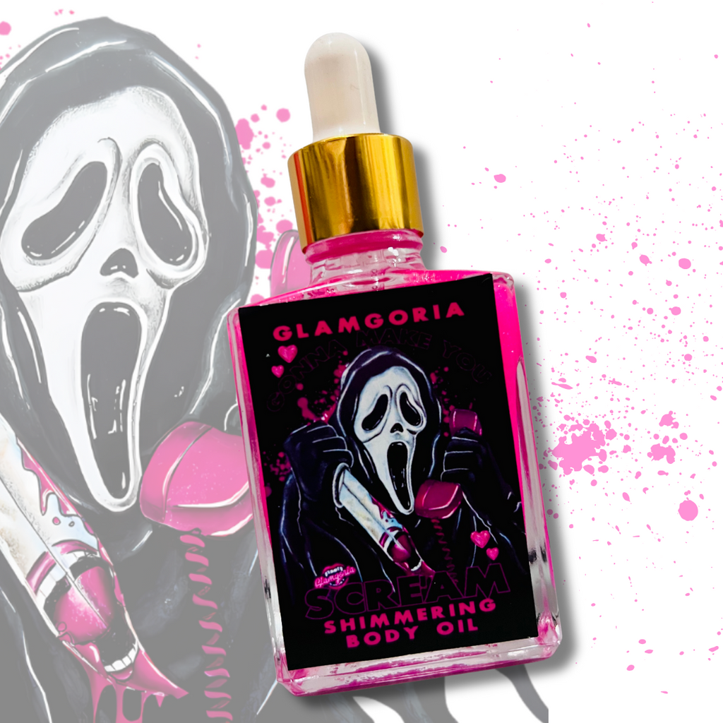 A square bottle of Glamgoria’s hot pink shimmering body oil labeled “Gonna Make You Scream,” featuring a ghost mask character holding a retro pink phone with hearts and pink splatter.