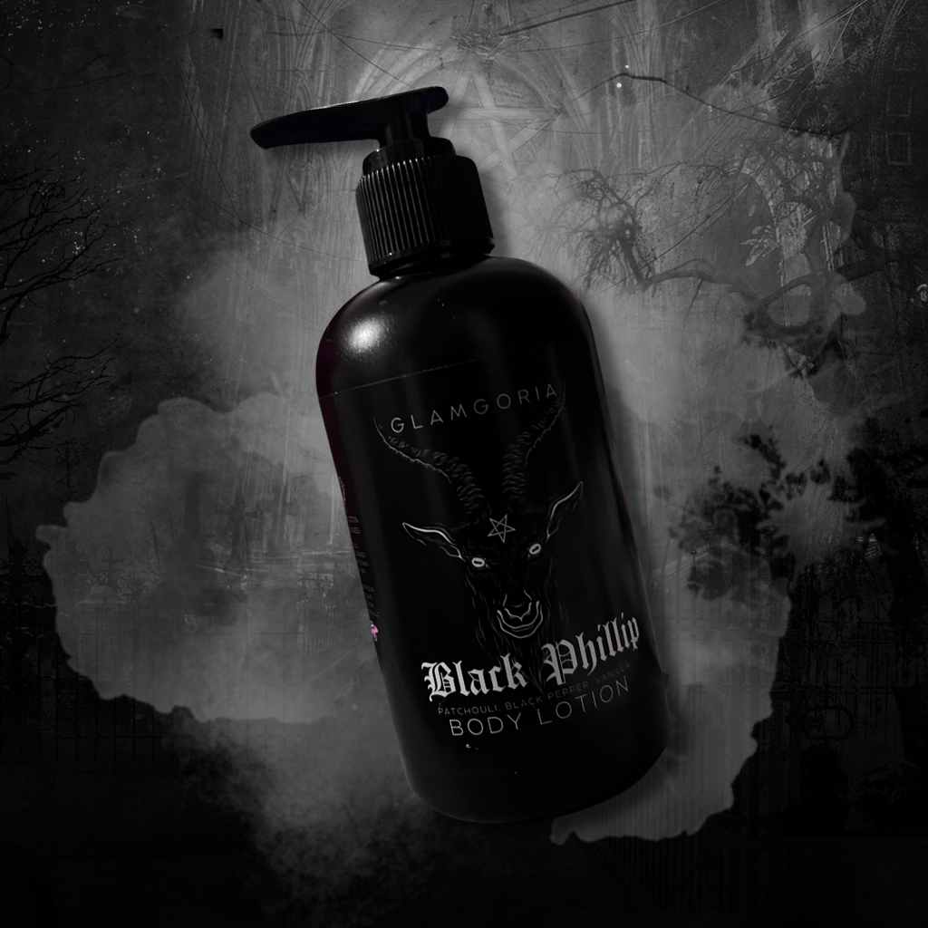 A sleek black bottle of Glamgoria’s Black Phillip Body Lotion, labeled with the goat head design and mystical accents. Set against a dark forest background.
