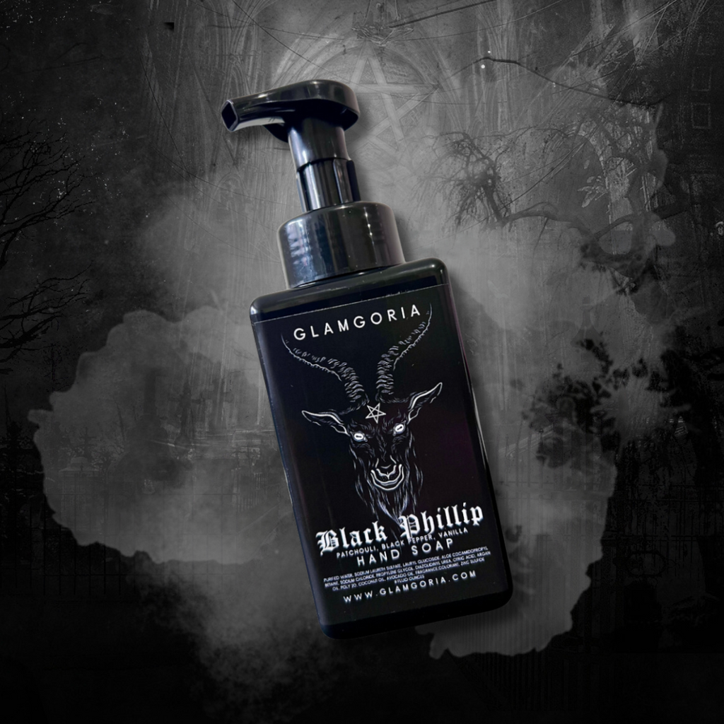 A matte black foaming soap dispenser featuring the same pentagram goat head label. Misty gray background for gothic ambiance.