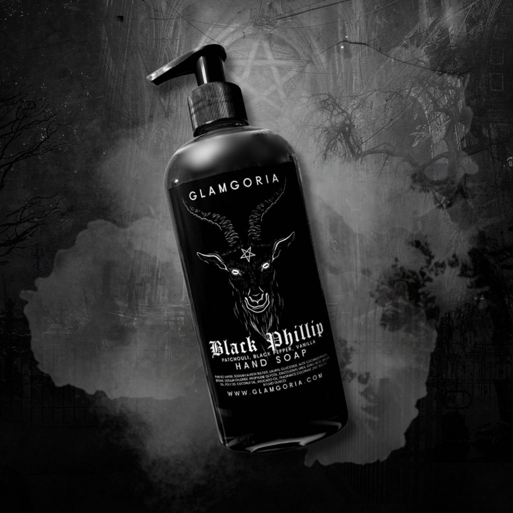Pump bottle of Black Phillip Hand Soap featuring a horned goat design with glowing eyes. Dark, moody backdrop with eerie fog.