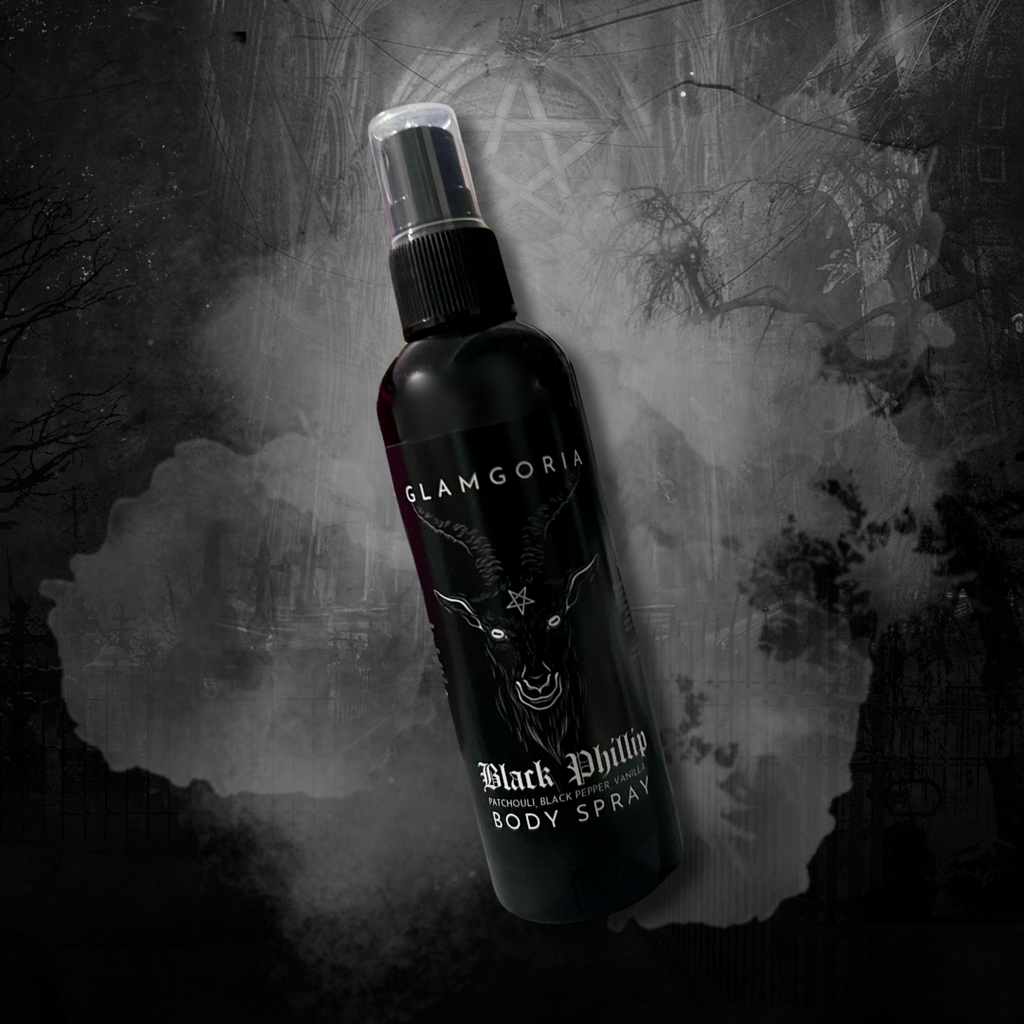 A black mist spray bottle with Glamgoria branding and the signature Black Phillip goat head icon. Surrounded by smoke and faint candlelight.