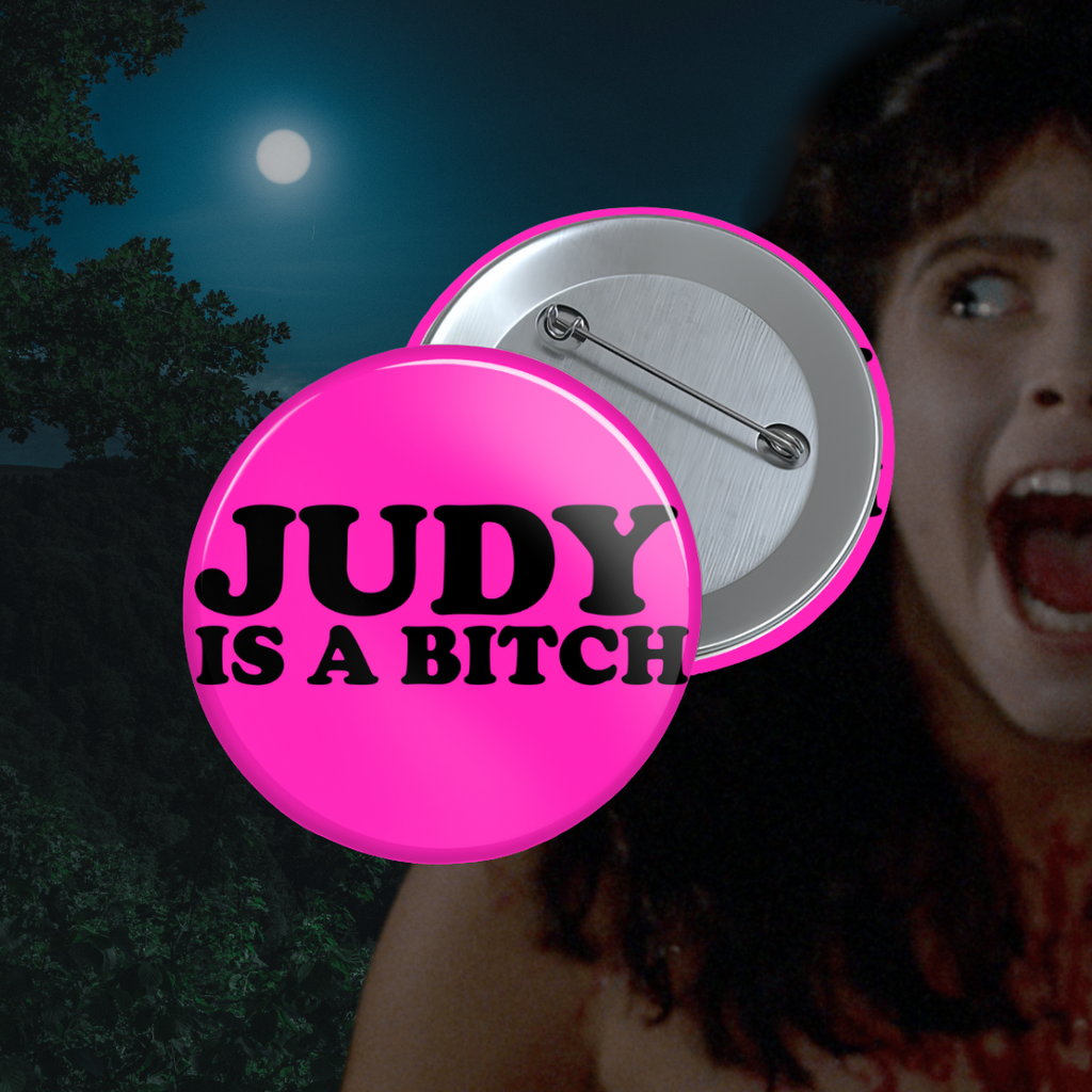 Bright pink pinback button with bold black text that says “JUDY IS A BITCH.”