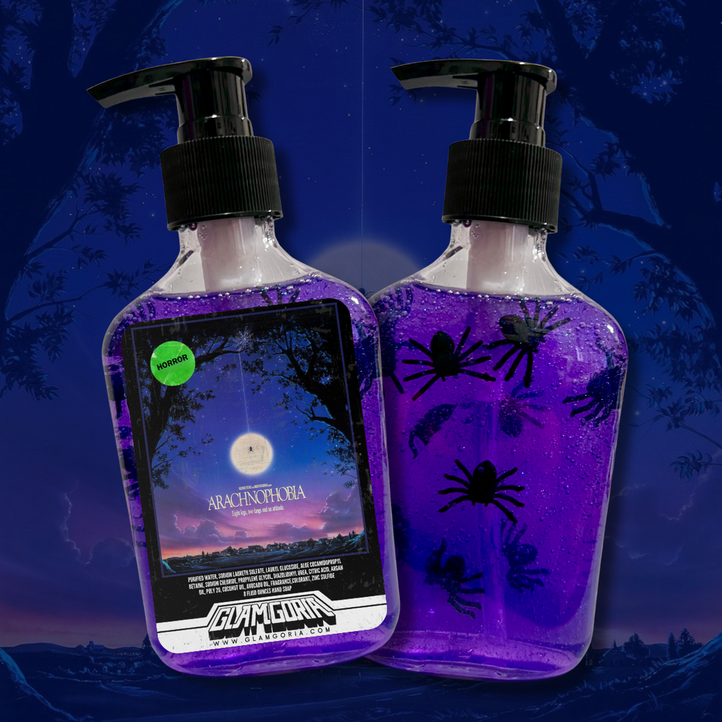 Two bottles of Glamgoria’s Arachnophobia hand soap, filled with purple gel and toy spiders. The front label features eerie artwork inspired by the Arachnophobia movie under a night sky.
