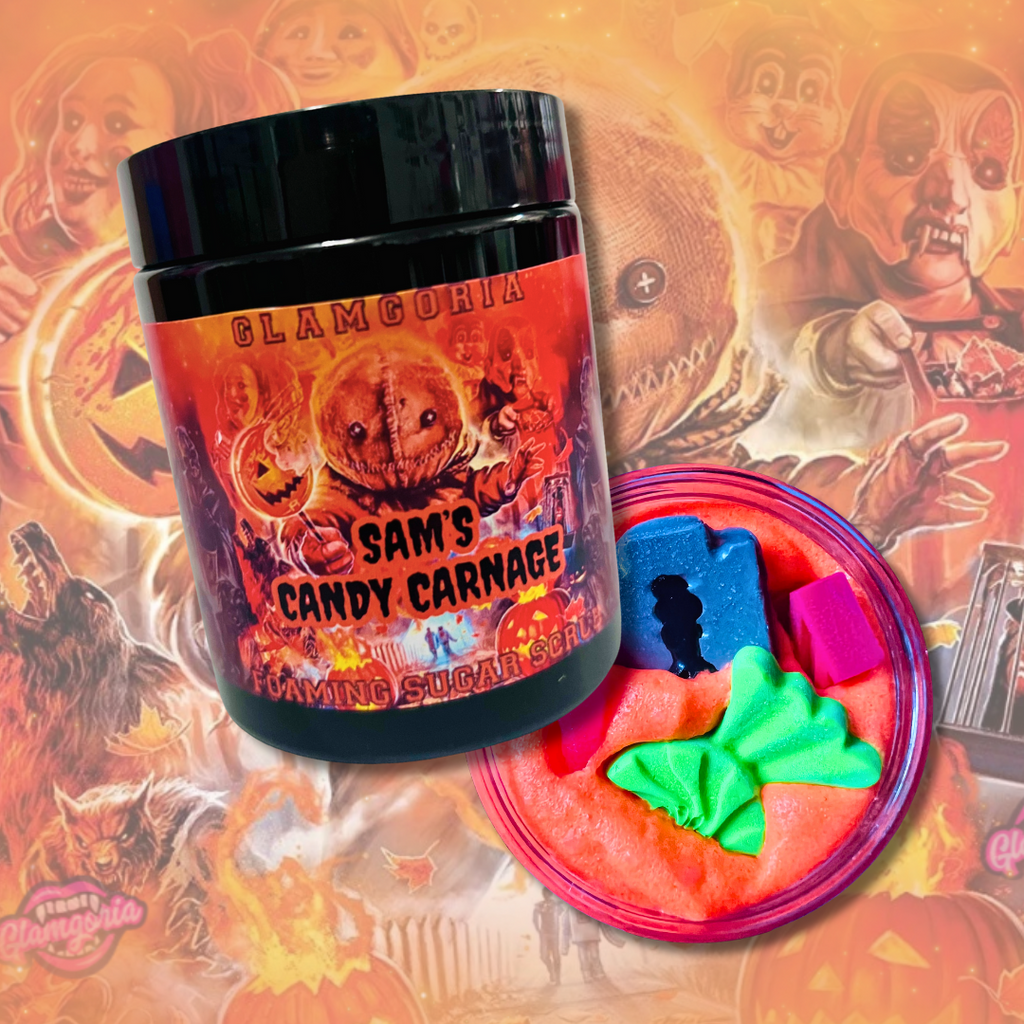 Jar of Glamgoria’s Sam’s Candy Carnage Foaming Sugar Scrub with bright orange whipped scrub inside, topped with colorful candy-shaped soap embeds.