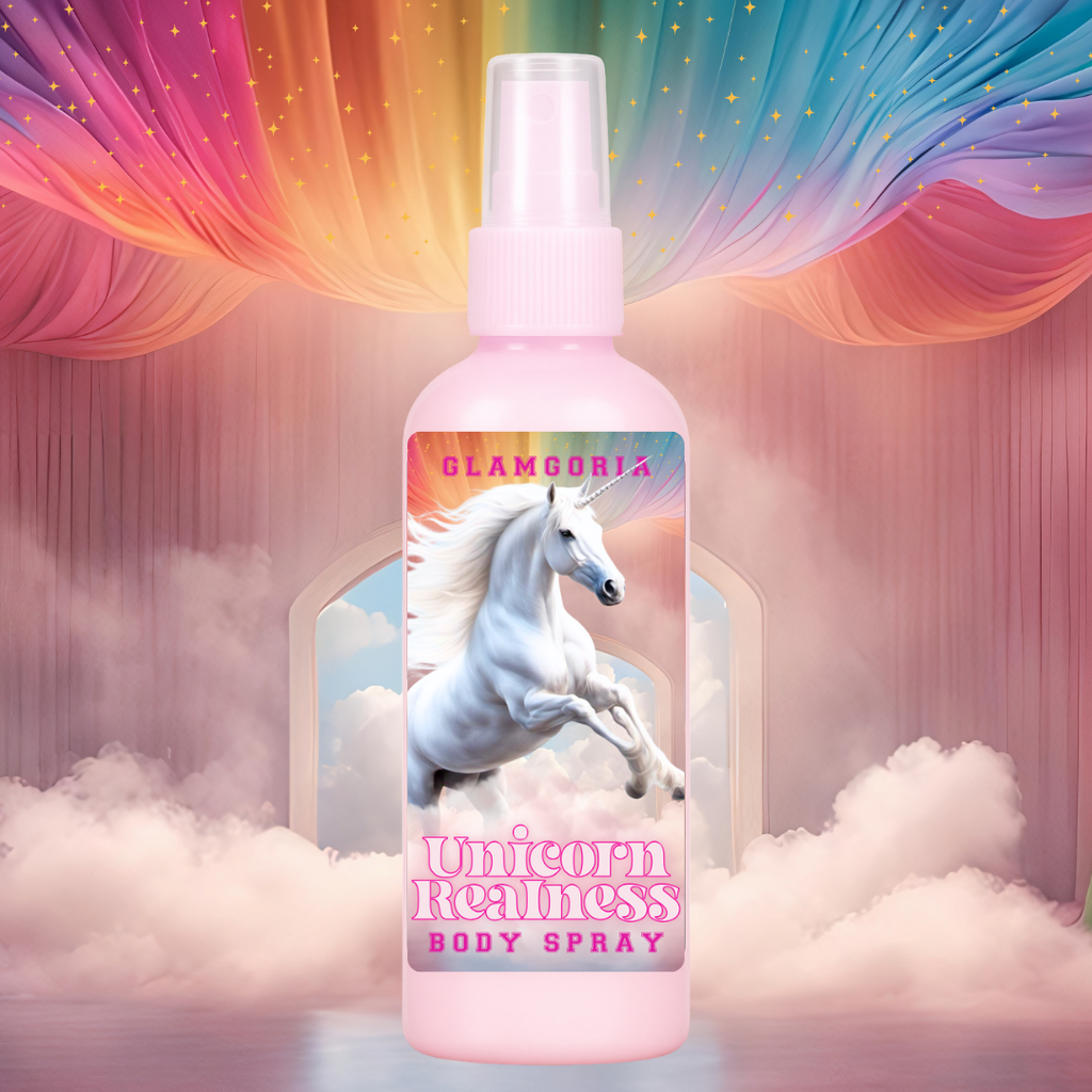 A pastel pink spray bottle of Glamgoria’s Unicorn Realness Body Spray with a label featuring a white unicorn galloping through clouds beneath a rainbow sky. The background includes dreamy curtains, misty clouds, and sparkling stars for a fantasy aesthetic.