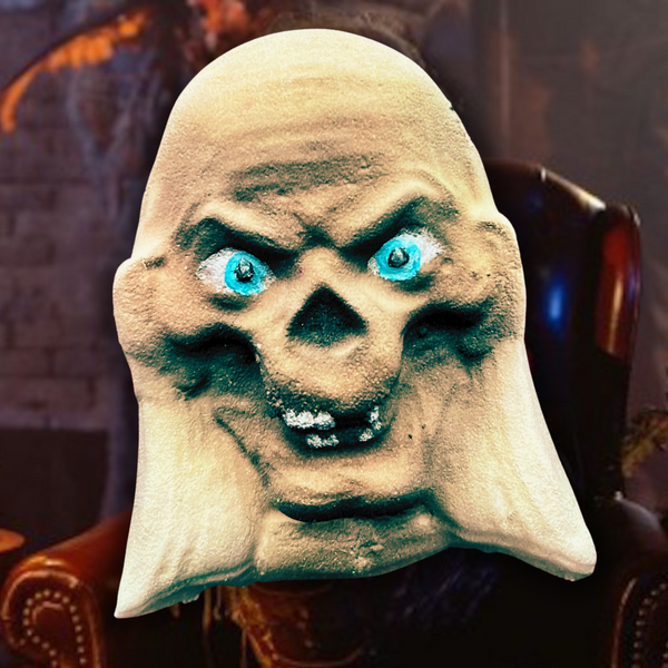 Cryptkeeper-inspired bath bomb styled as a skeletal ghoul with glowing blue eyes, dressed in a tuxedo and holding an old book, set against a dark, gothic background with Glamgoria logo.