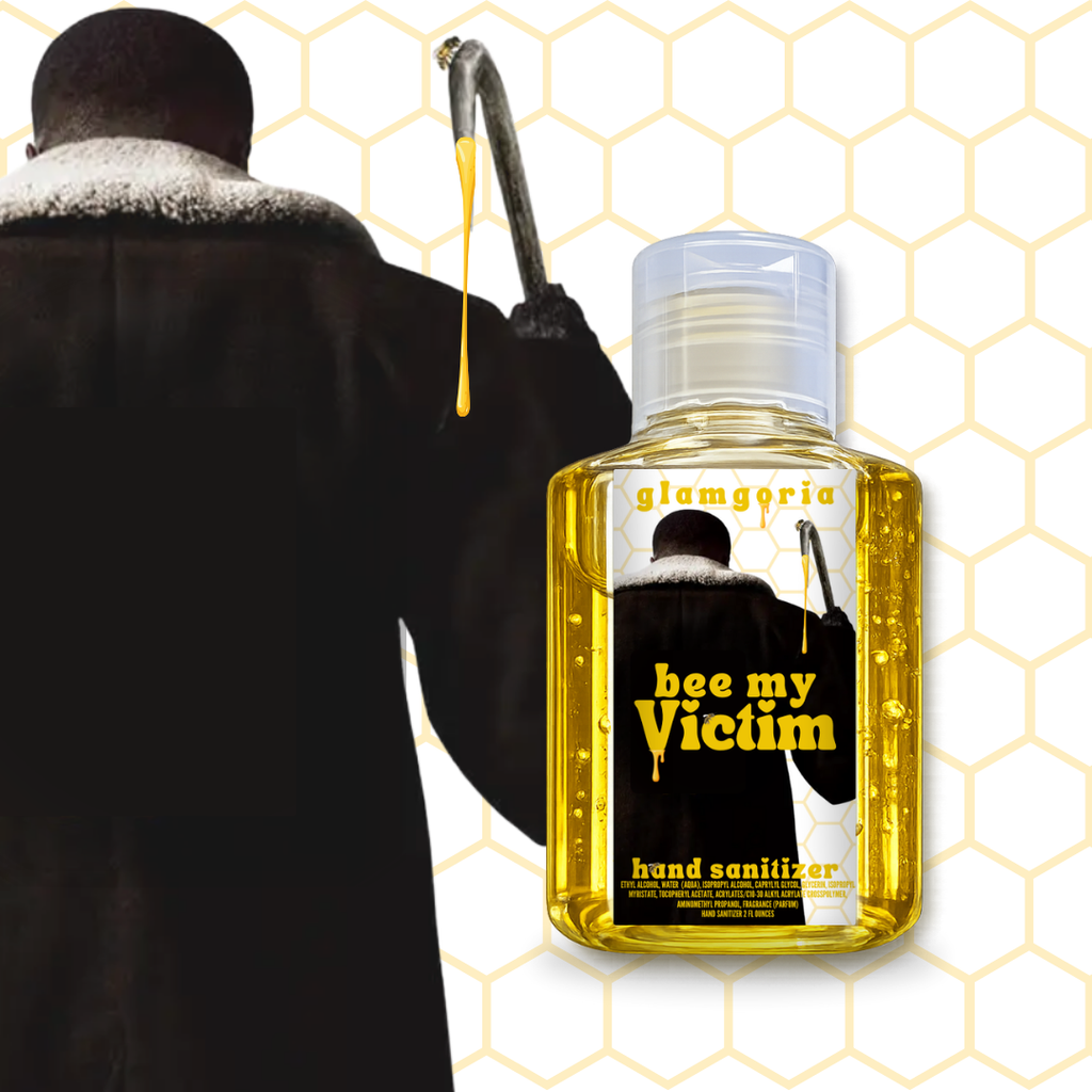 Clear hand sanitizer bottle filled with golden yellow liquid labeled “Bee My Victim” with honeycomb background