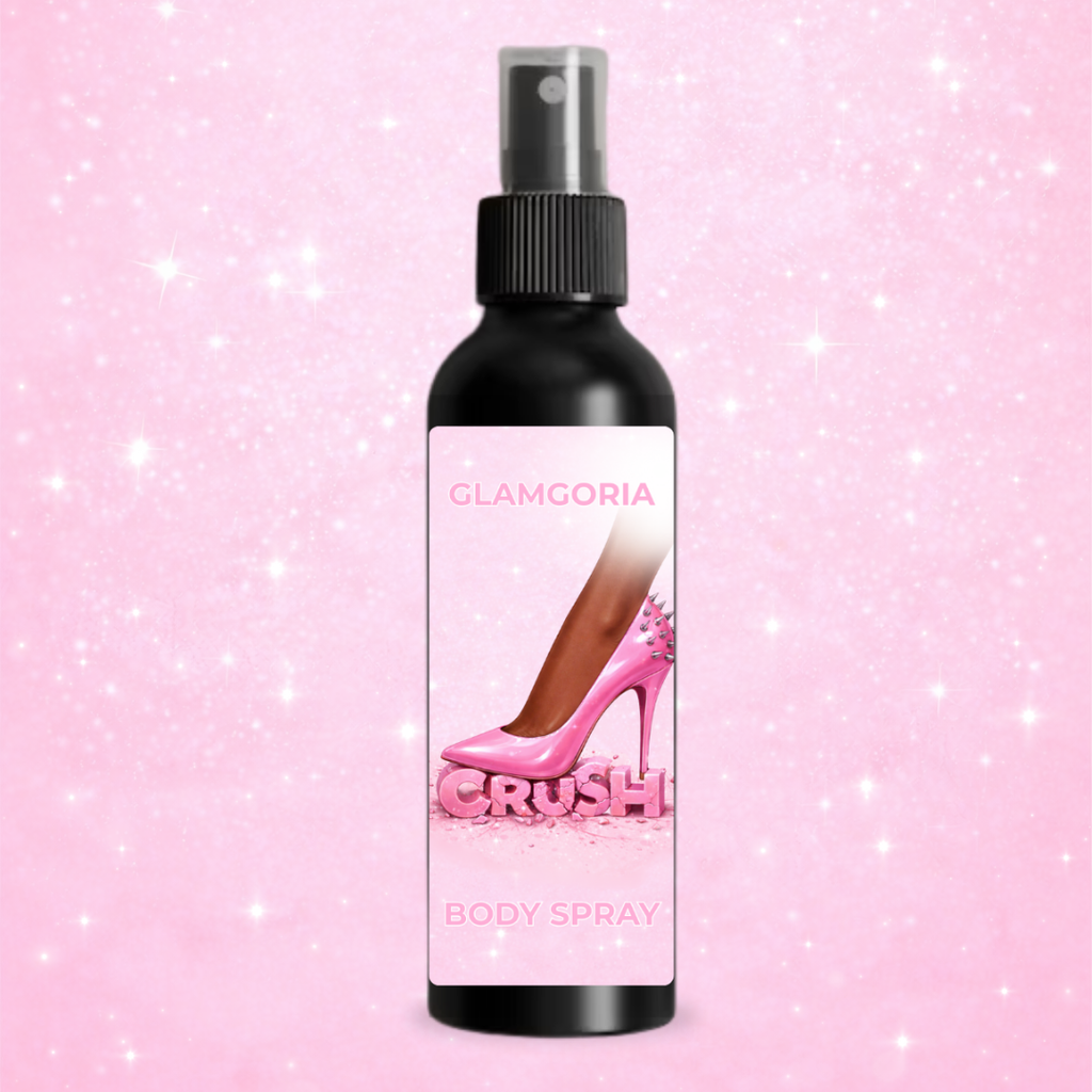 CRUSH body spray in a black bottle with a spray top, featuring a pink label with a spiked high heel crushing the word “crush” on a soft pink glitter background.
