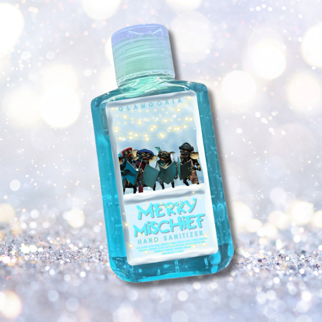 Blue glitter hand sanitizer bottle with a Merry Mischief gremlin-themed holiday label featuring creepy carolers on a sparkling winter background.