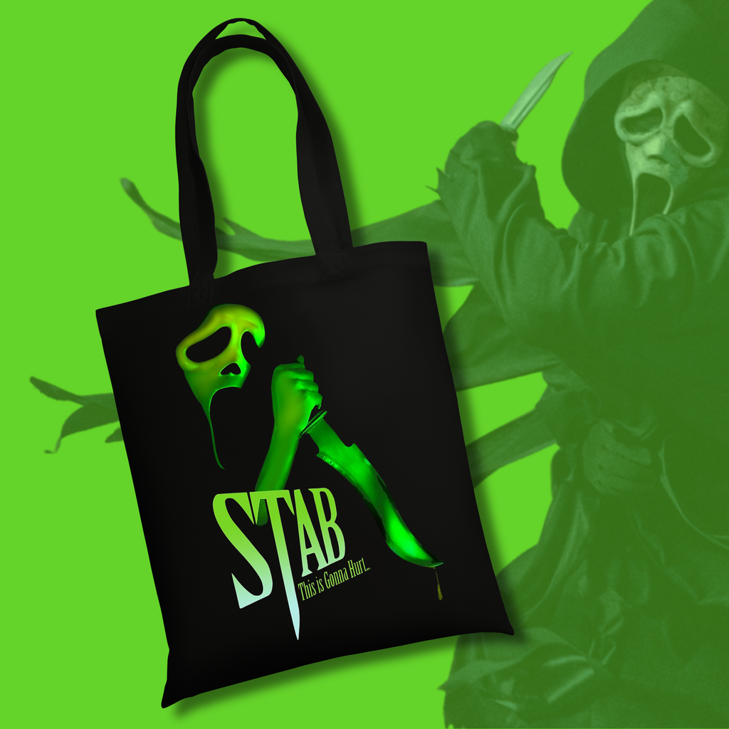 
Black tote bag featuring neon green slasher-inspired artwork with a masked figure holding a knife and the text “STAB – This Is Gonna Hurt” on a bright green background.