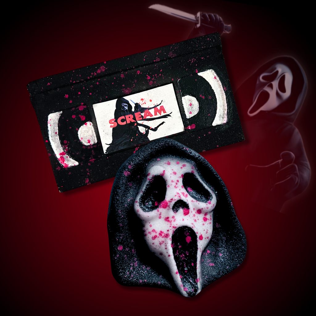 Set of black ghostface-inspired bath bombs with pink and red splatter details displayed together.

