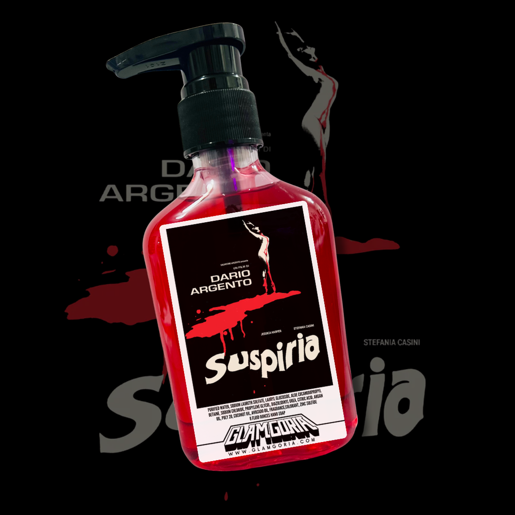 A bottle of Glamgoria’s Suspiria hand soap filled with deep red liquid, featuring the iconic vintage poster of a dancer standing over a dripping pool of blood on a dark, dramatic background.