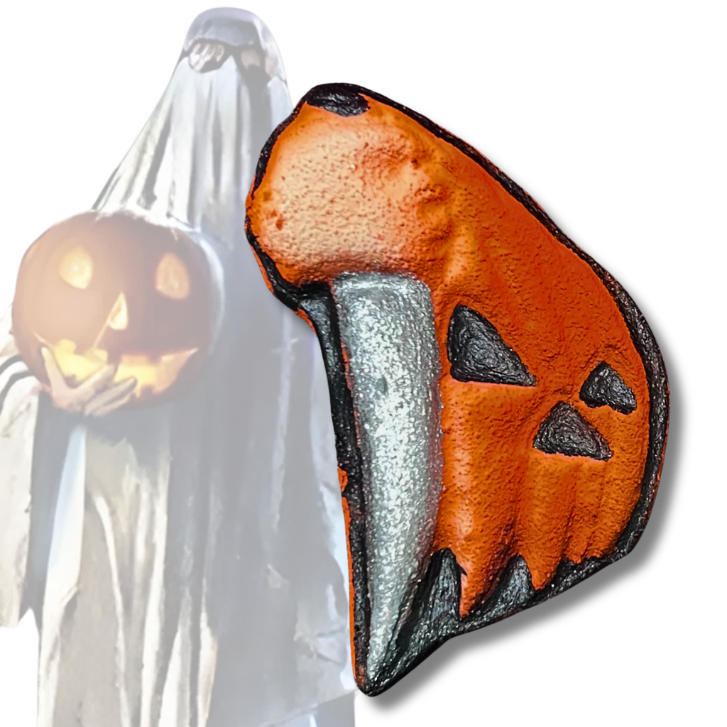 Halloween 78 bath bomb shaped like a jack-o’-lantern kitchen knife, painted orange and silver with black details, inspired by the slasher classic.
