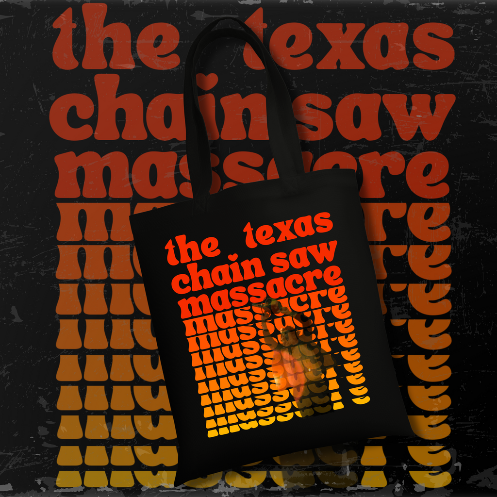 Black tote bag with retro orange and yellow gradient text reading “The Texas Chain Saw Massacre,” featuring Leatherface swinging a chainsaw in the middle of the design.